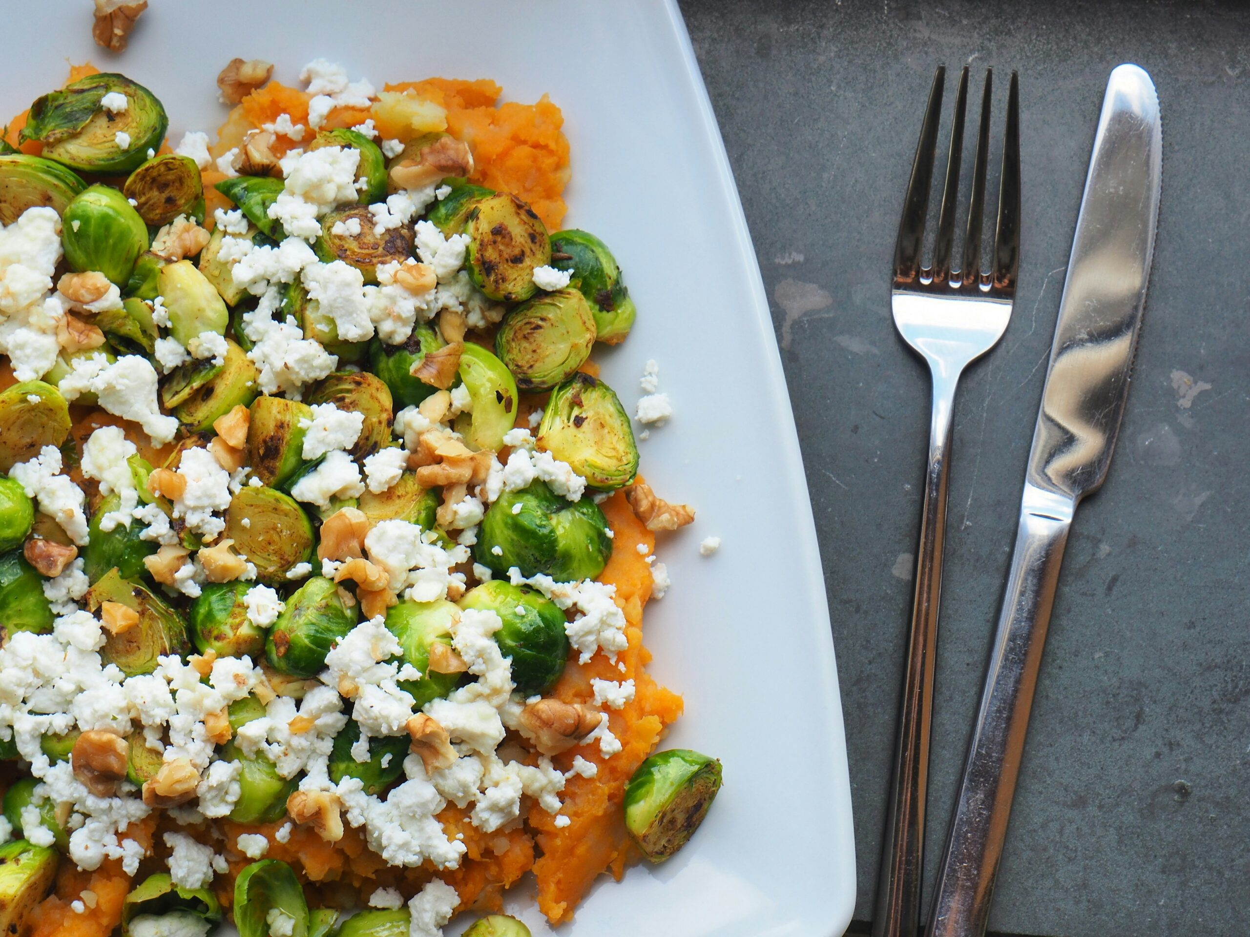 stainless steel dinner knife and fork beside cooked vegetable