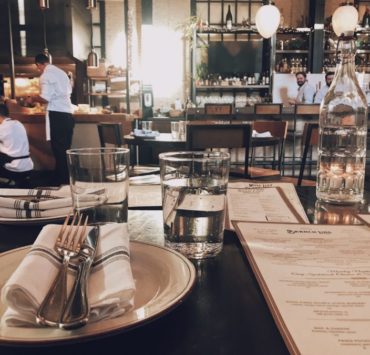 fork and knife on plate beside drinking glass