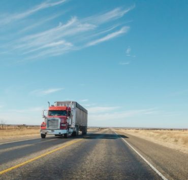 trailer truck passing on road during daytime