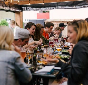 people sitting in front of table talking and eating
