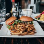 selective focus photo of burgers and fries served on plate
