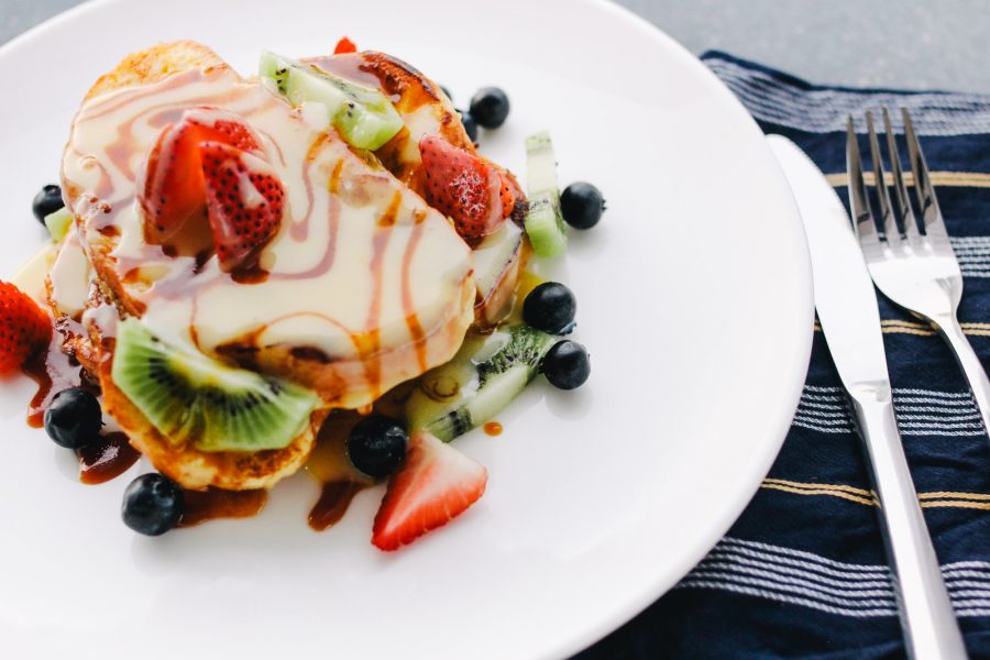plate of pancake with strawberry and kiwi toppings