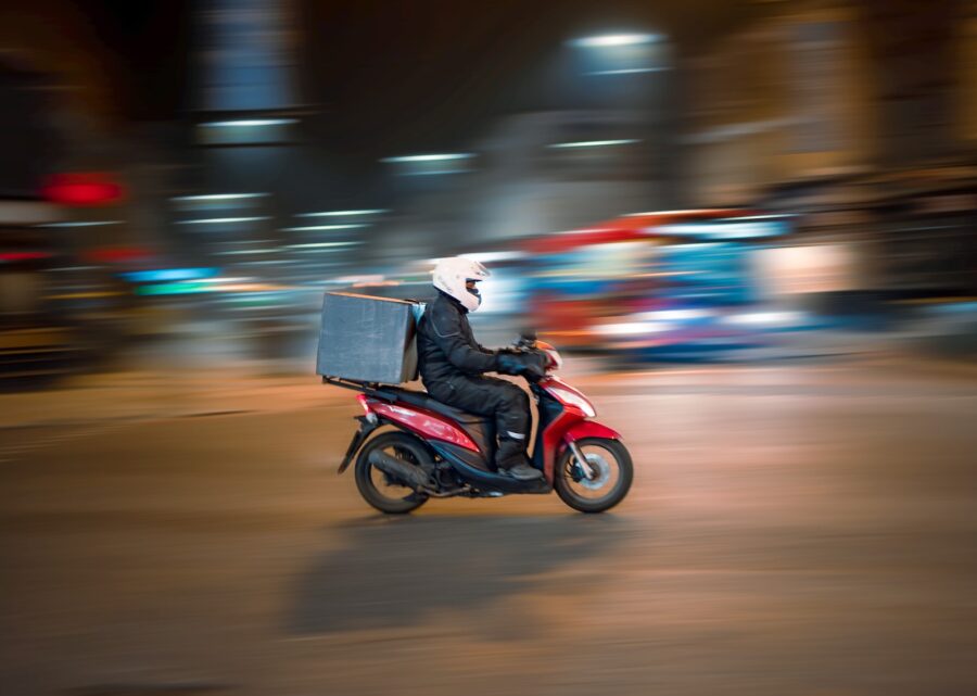 delivery stocks, man riding motorcycle on road during daytime