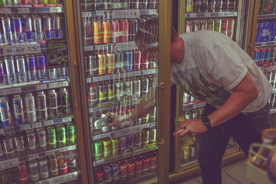 man getting can in beverage cooler, energy drink stocks