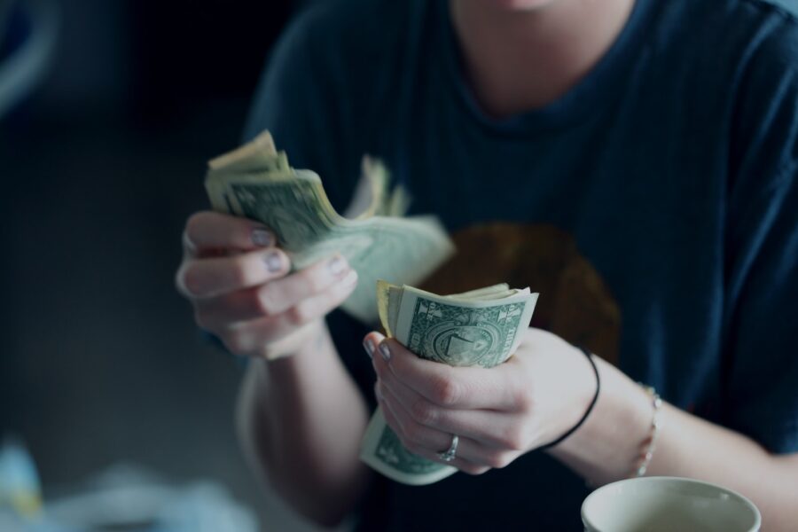 focus photography of person counting dollar banknotes, economic pressure