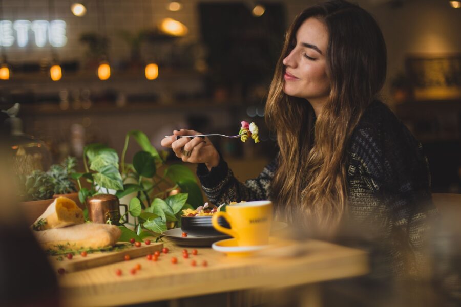 woman holding fork in front table, plant-based