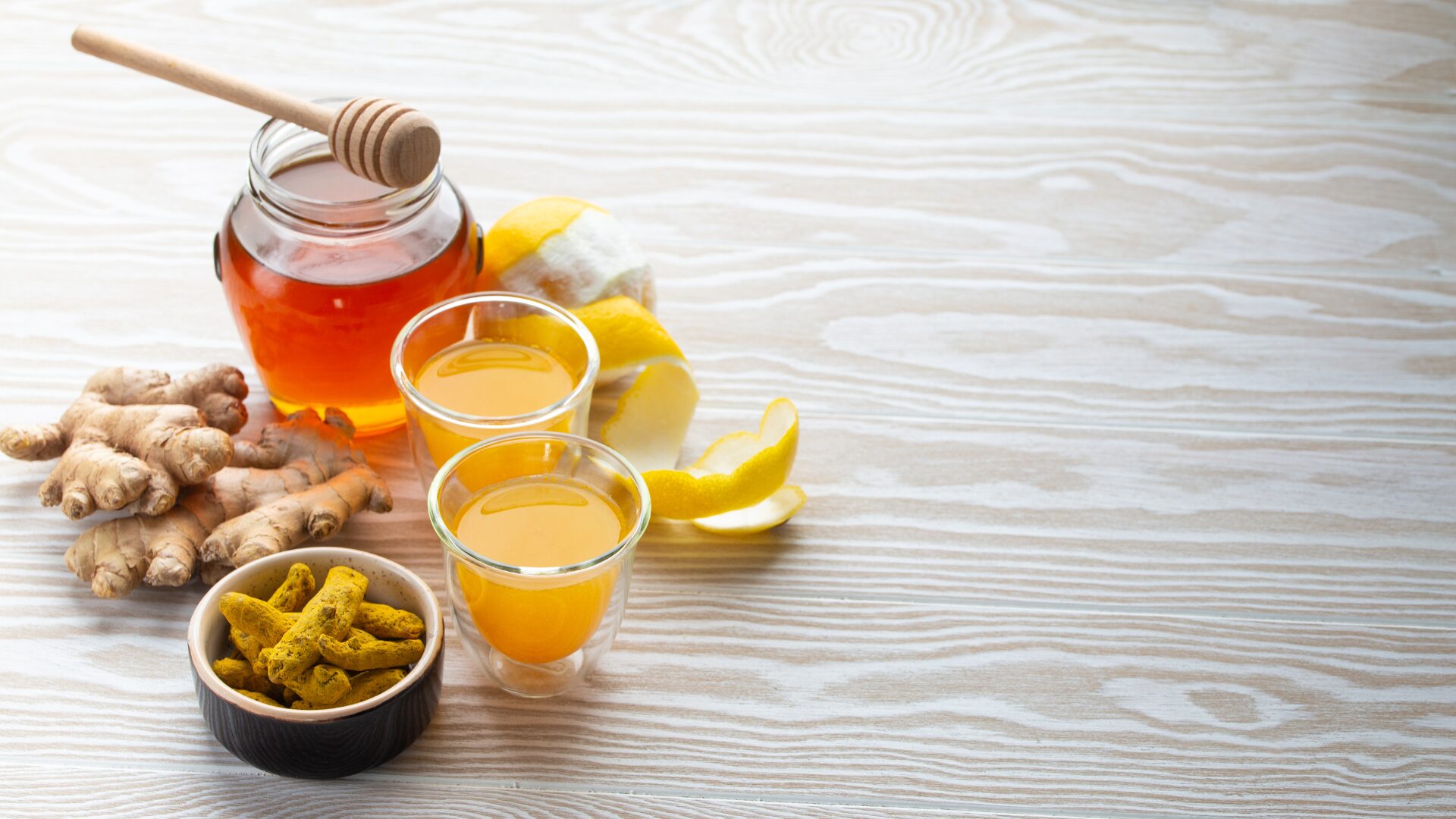 Immunity-boosting wellness shots with turmeric, ginger, lemon, honey.