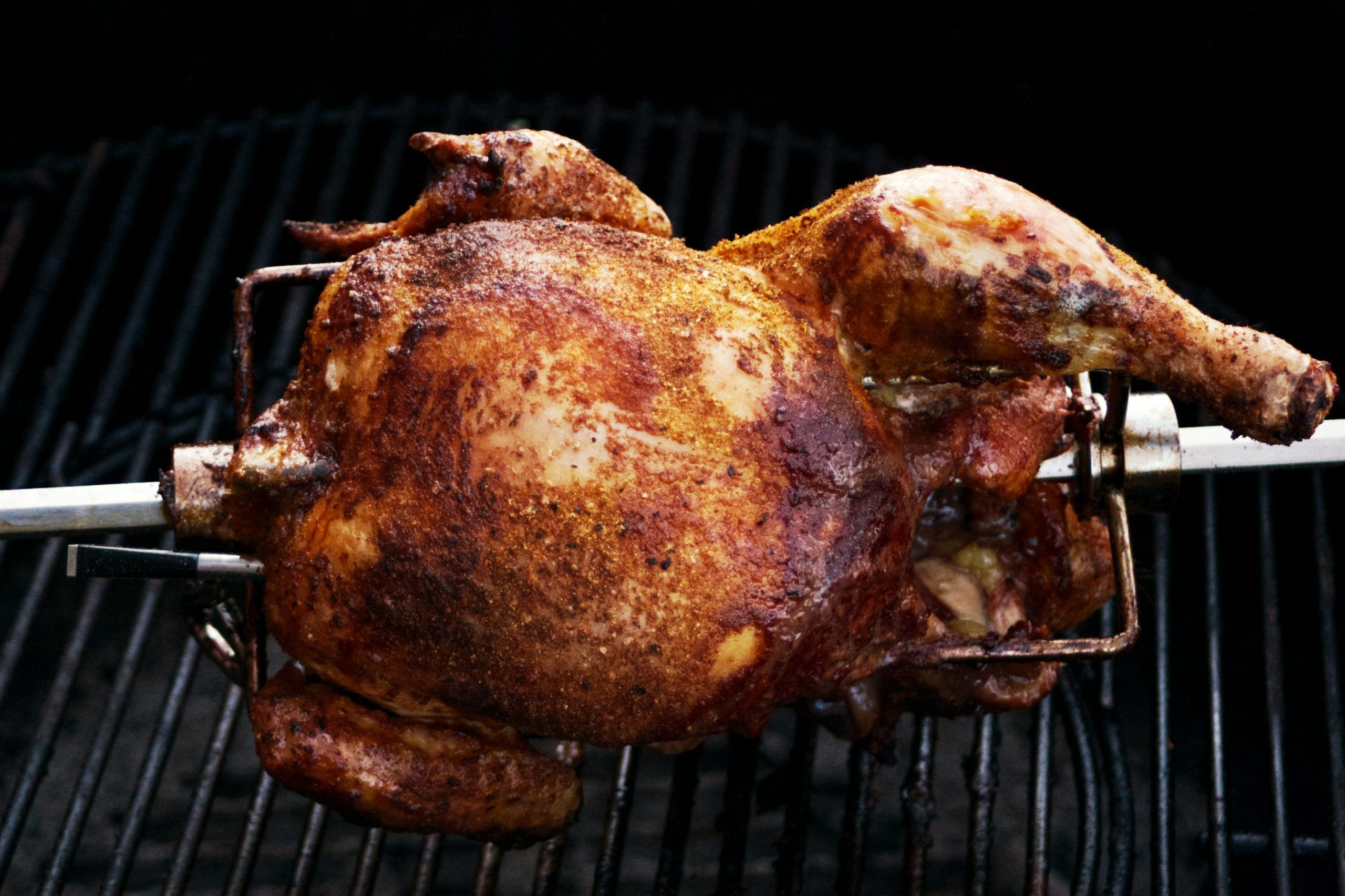 a whole chicken is cooking on a grill