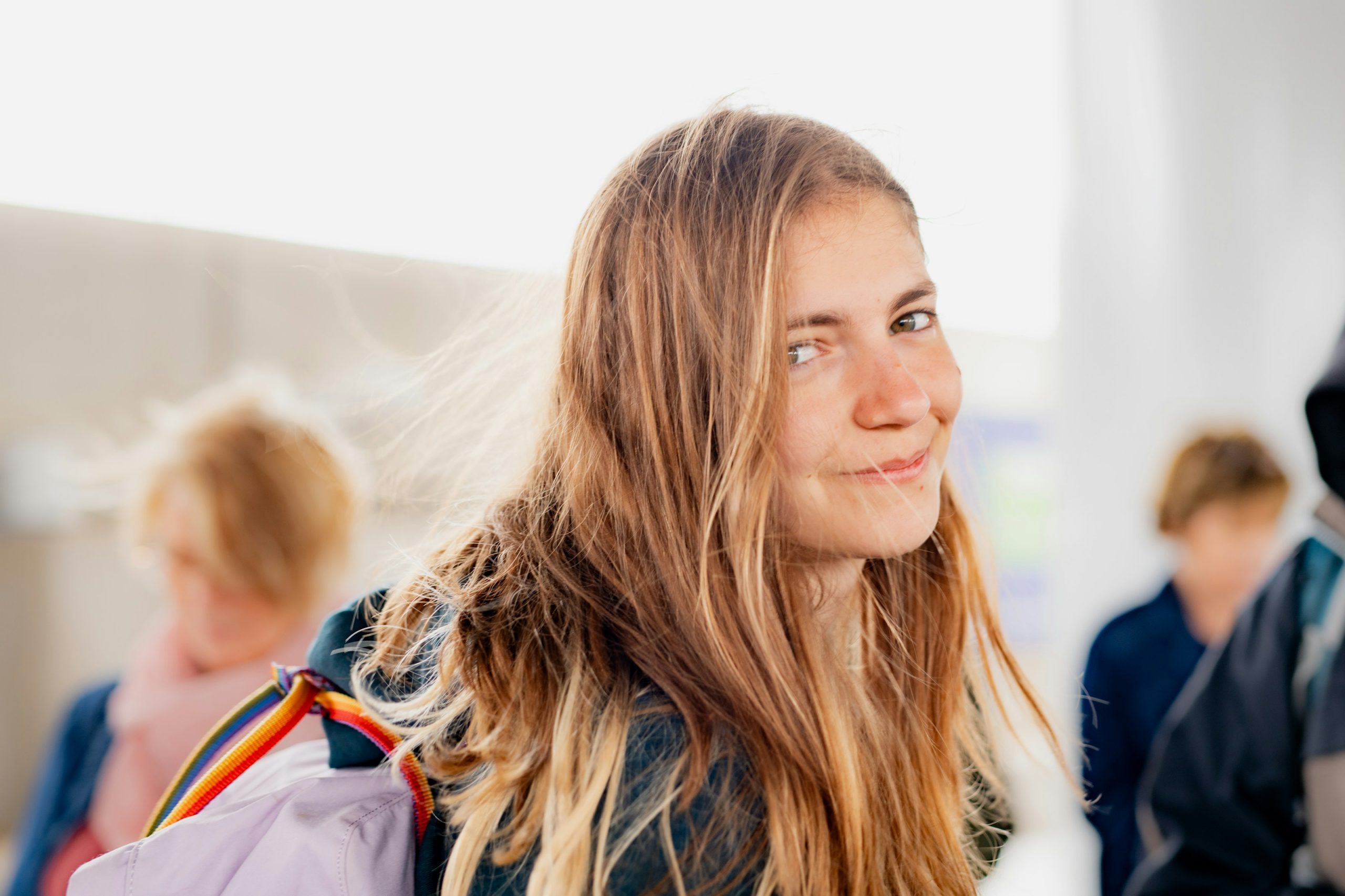 a woman with long hair and a backpack